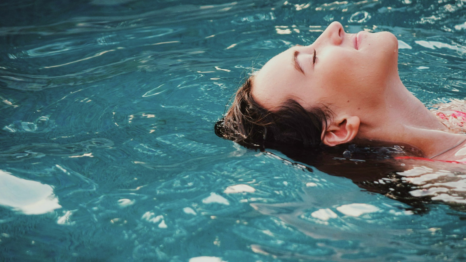 Mujer relajándose en el agua de una piscina