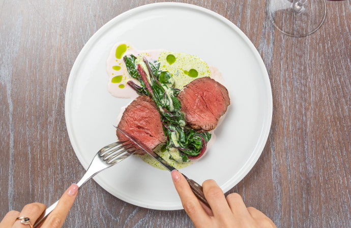 Plate of juicy meat accompanied by vegetables