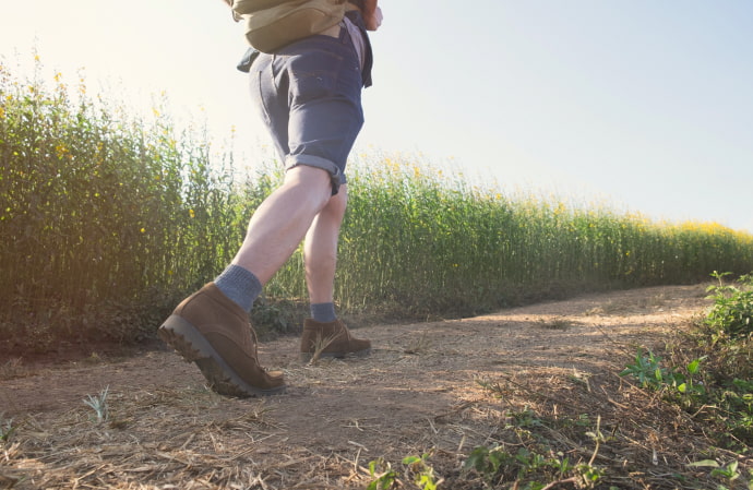 Person wearing hiking boots walking along a gentle slope path