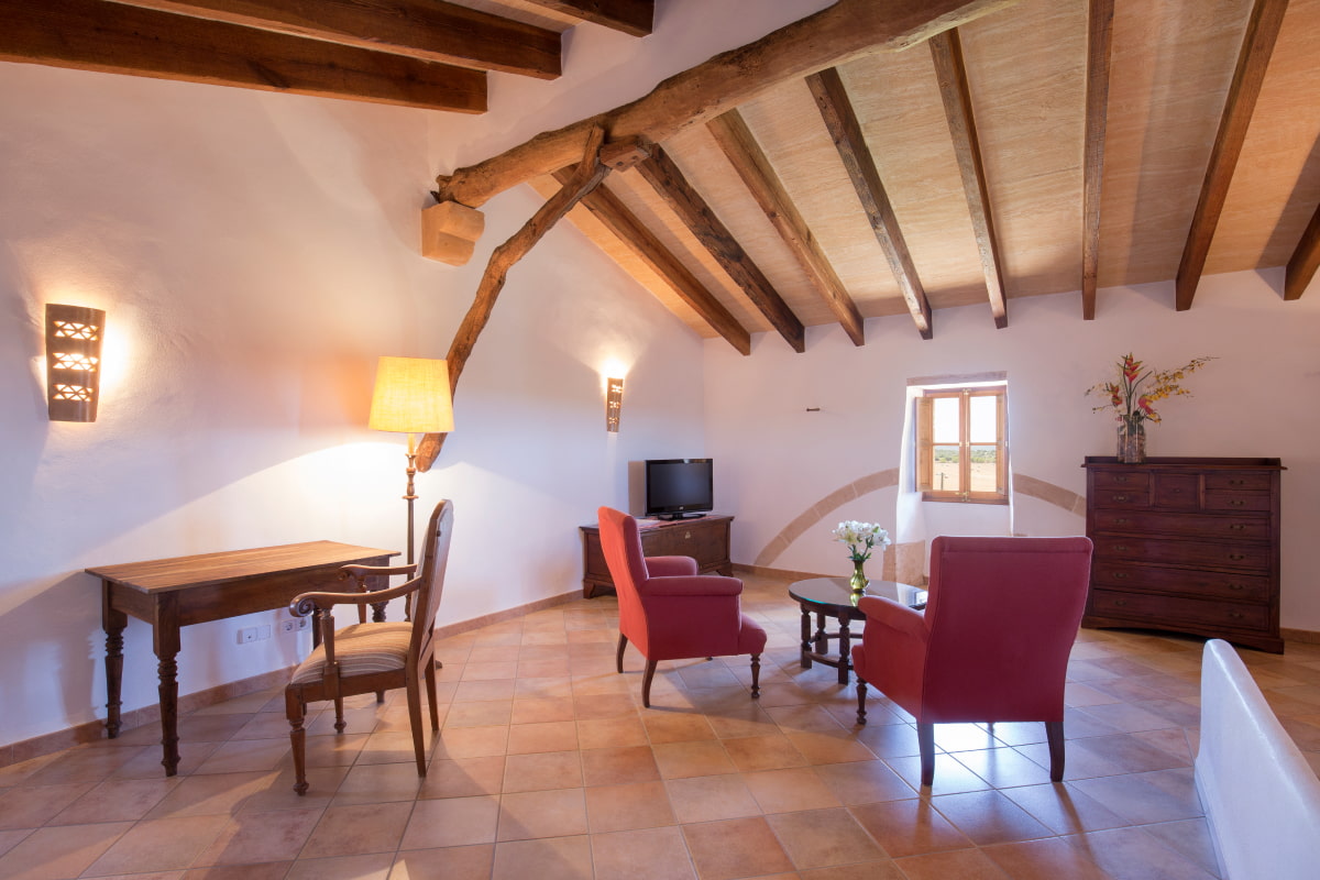 Room with seating area and exposed beams.