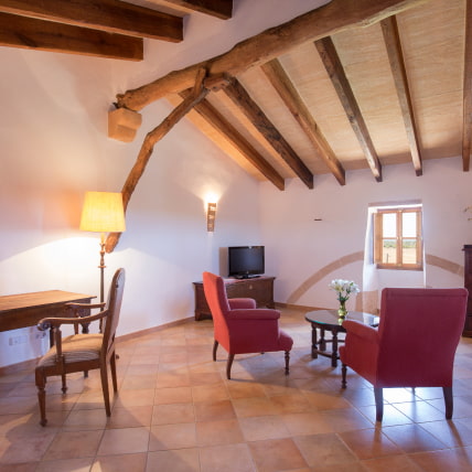 Room with seating area and exposed beams.