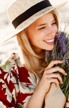 Joven sonriente sosteniendo un ramo de flores